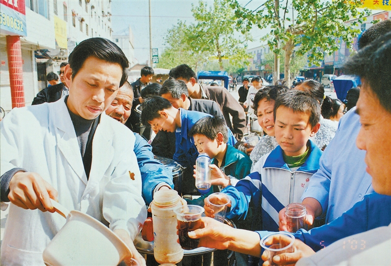 王忠玉带领医务人员走进农村,免费为百姓煎服预防疾病的中药汤剂