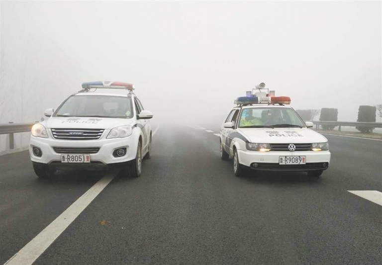 雾锁高速,在日兰高速菏泽段,警车压车带道. 记者 张 啸 摄