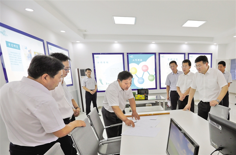在德成创新工作室,牛德成向山东省电力公司总经理蒋斌介绍发明