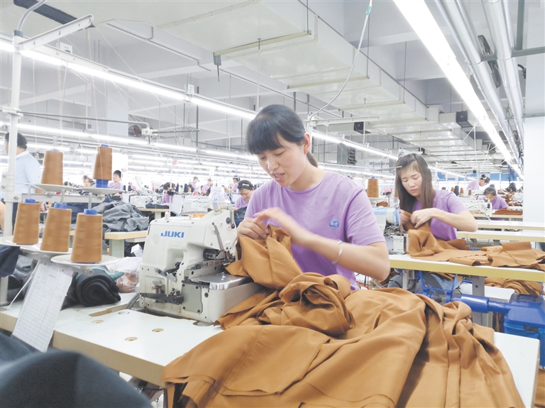 38岁的村民杨秋凤在万丽时装厂缝纫车间赶制出口订单